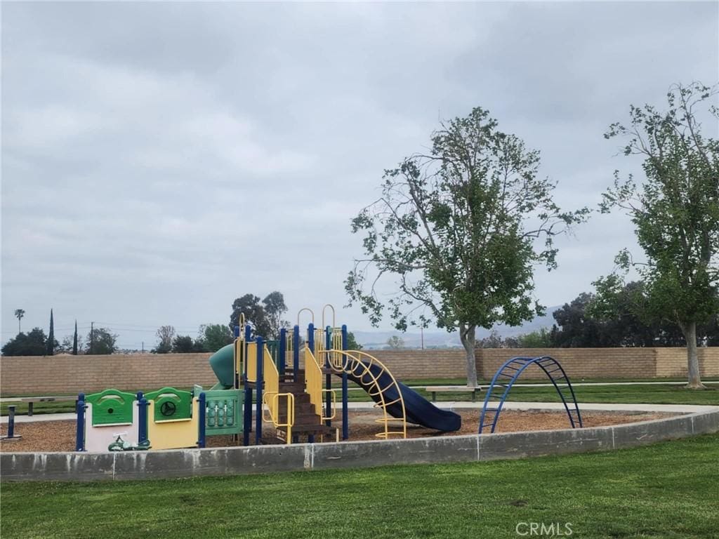 community playground featuring a yard and fence