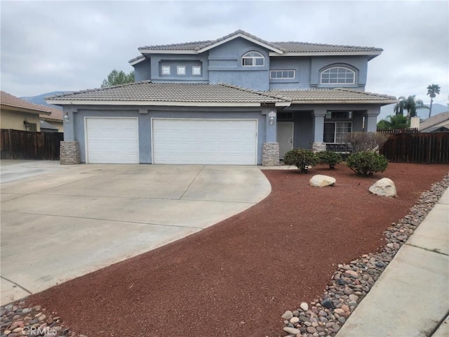 traditional home featuring stucco siding, driveway, and fence