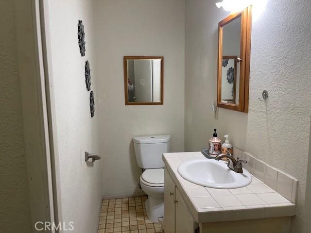 half bathroom with vanity and toilet