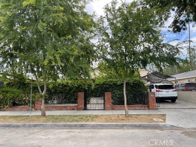 obstructed view of property featuring a fenced front yard and a carport
