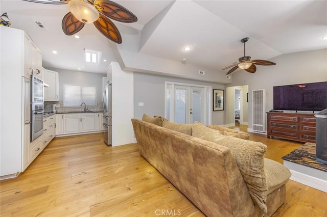 16512 23rd St, Sunset Beach, CA 90742 - living room with lofted ceiling, french doors, visible vents, ceiling fan, and light wood-style flooring
