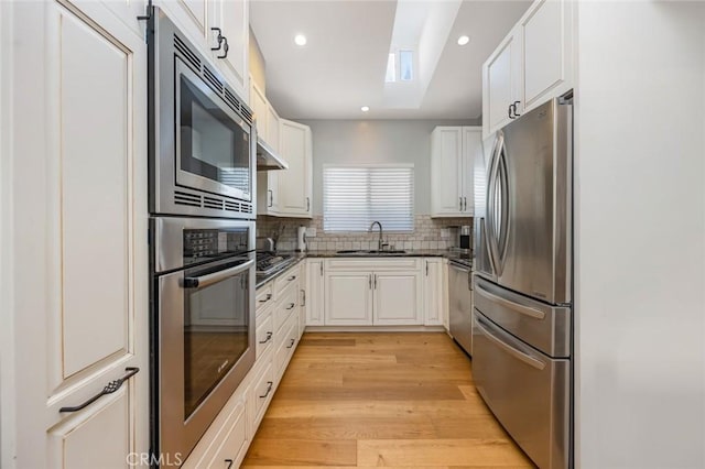 16512 23rd St, Sunset Beach, CA 90742 - kitchen with white cabinets, a skylight, appliances with stainless steel finishes, and a sink