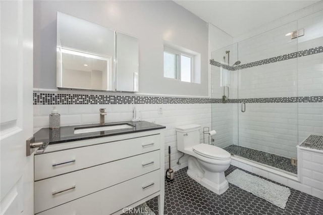 16512 23rd St, Sunset Beach, CA 90742 - bathroom featuring tile walls, tile patterned flooring, a shower stall, vanity, and toilet