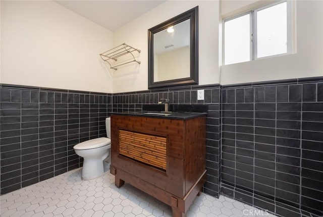 16512 23rd St, Sunset Beach, CA 90742 - half bathroom with tile walls, wainscoting, tile patterned flooring, toilet, and vanity