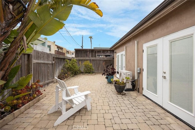 16512 23rd St, Sunset Beach, CA 90742 - view of patio featuring french doors, a fenced backyard, and a cooling unit