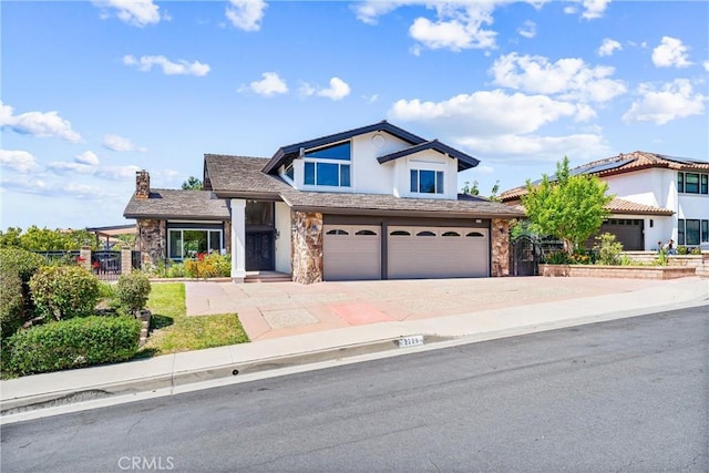 2223 E Vista Mesa Way, Orange, CA 92867 - view of front of house featuring stone siding, a garage, driveway, and a chimney