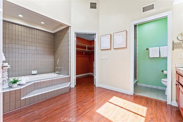 2223 E Vista Mesa Way, Orange, CA 92867 - bathroom with wood finished floors, toilet, tiled shower, vanity, and a relaxing tiled tub