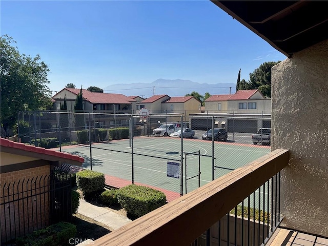 view of sport court with community basketball court, fence, and a residential view
