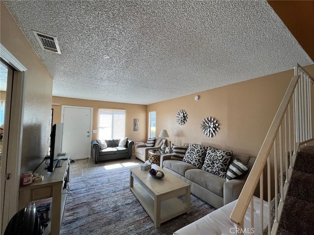 living room featuring a textured ceiling and visible vents