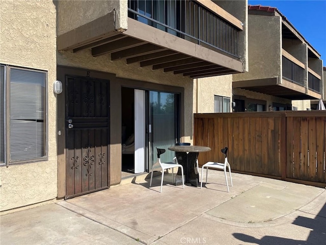 view of patio / terrace featuring fence and a balcony