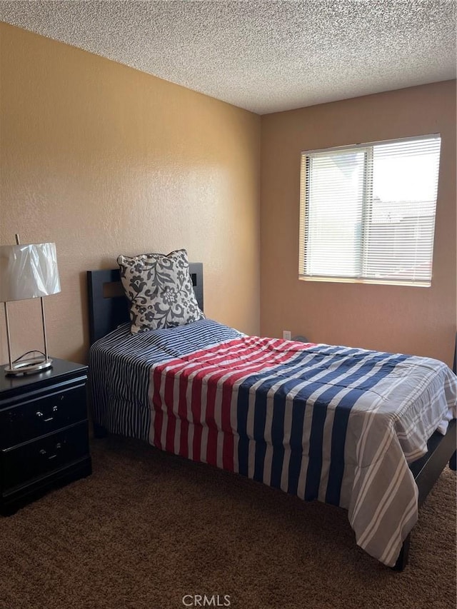 bedroom with carpet flooring and a textured ceiling