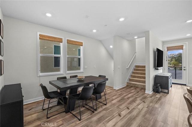 dining room with light wood-type flooring, recessed lighting, stairs, and baseboards