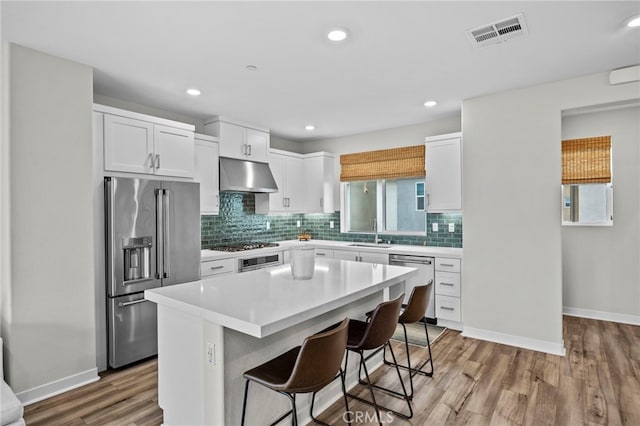 31 Jubilee Way, Rancho Mission Viejo, CA 92694 - kitchen featuring stainless steel appliances, under cabinet range hood, backsplash, a center island, and white cabinets