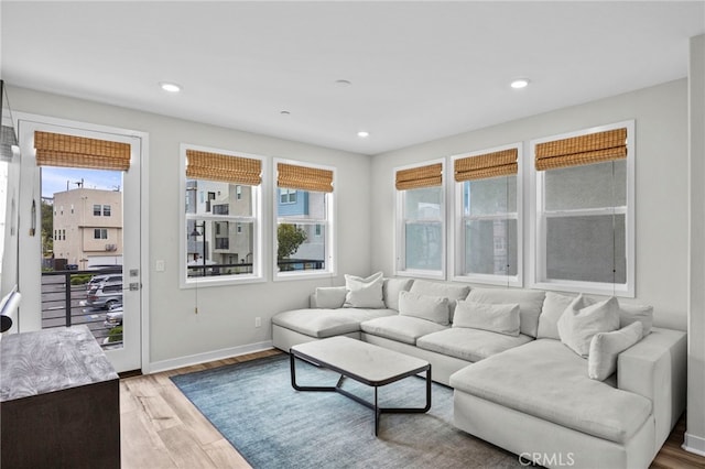 living room featuring light wood-style floors, recessed lighting, and plenty of natural light