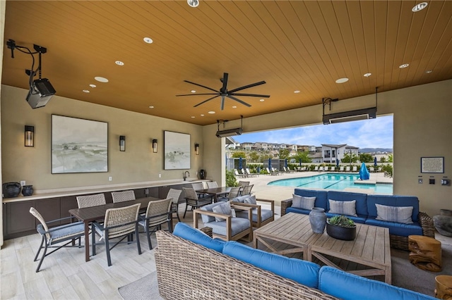 view of patio featuring a community pool, a ceiling fan, outdoor dining space, and outdoor lounge area