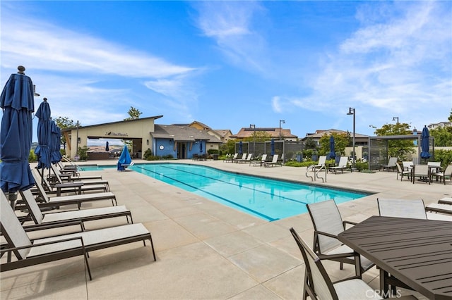 community pool featuring fence and a patio