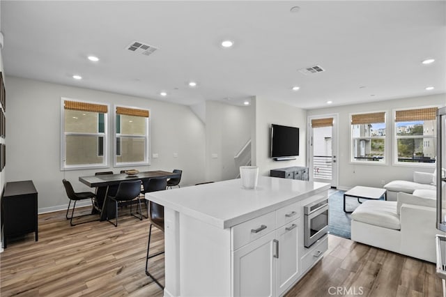 kitchen featuring light wood-style floors, visible vents, and open floor plan