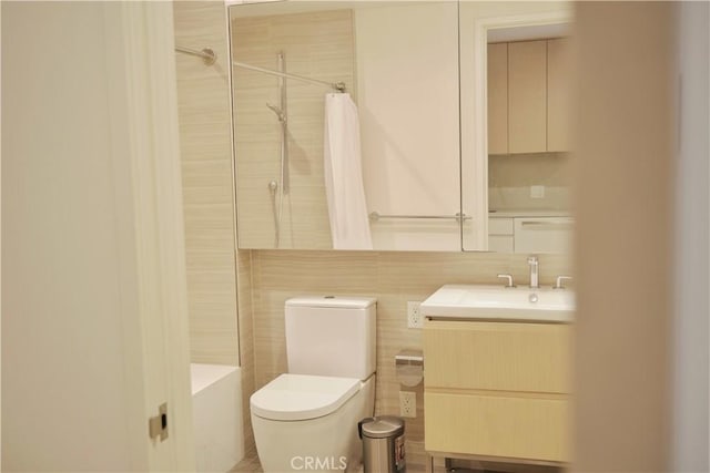 full bath with toilet, tile walls, and vanity
