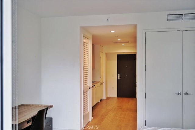 corridor with light wood-type flooring, recessed lighting, and visible vents