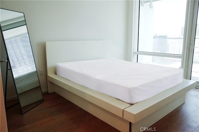 bedroom with dark wood-style flooring