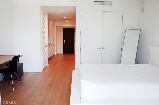 bedroom with recessed lighting, a closet, light wood-type flooring, and visible vents