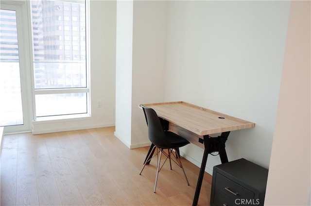 home office with baseboards and light wood finished floors