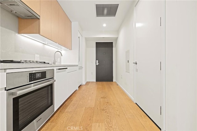 877 Francisco St Unit 1723, Los Angeles, CA 90017 - kitchen featuring stainless steel appliances, under cabinet range hood, light wood-type flooring, modern cabinets, and light countertops