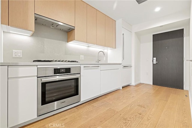 877 Francisco St Unit 1723, Los Angeles, CA 90017 - kitchen with oven, under cabinet range hood, gas stovetop, light wood finished floors, and light countertops