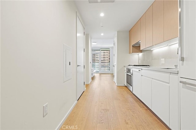 877 Francisco St Unit 1723, Los Angeles, CA 90017 - kitchen featuring under cabinet range hood, light wood-type flooring, stainless steel appliances, light countertops, and recessed lighting