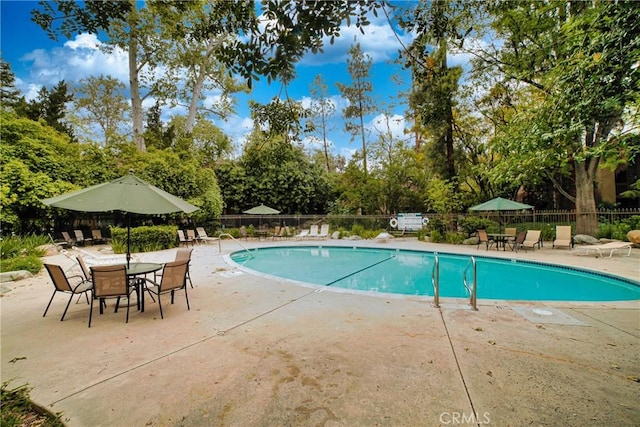 pool with fence and a patio