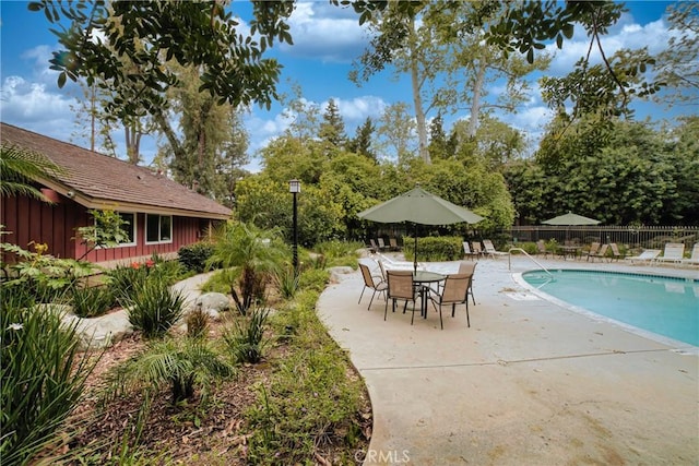 community pool featuring fence and a patio