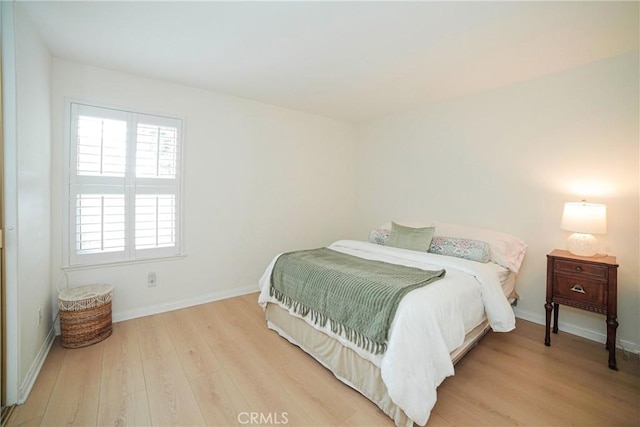 bedroom featuring baseboards and wood finished floors