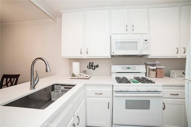 kitchen featuring white appliances, white cabinets, and a sink