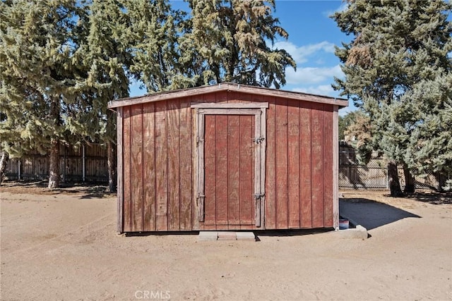 view of shed featuring fence