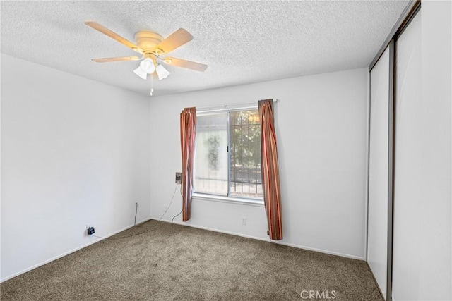empty room with a textured ceiling, carpet, and ceiling fan