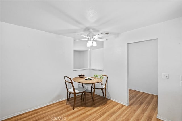 dining room with ceiling fan, baseboards, and light wood finished floors