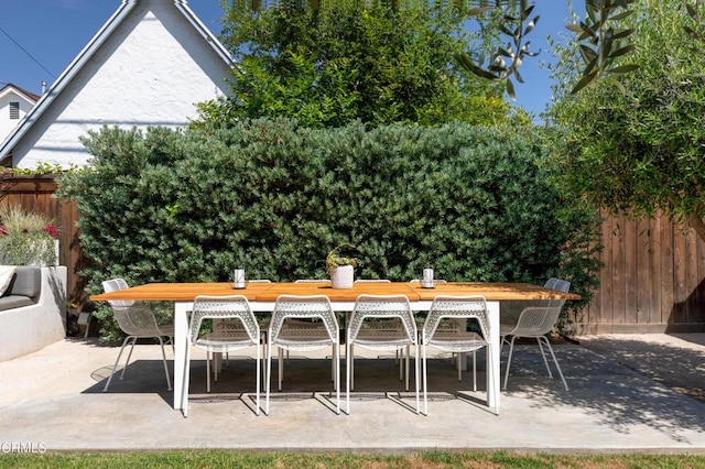view of patio featuring fence and outdoor dining space