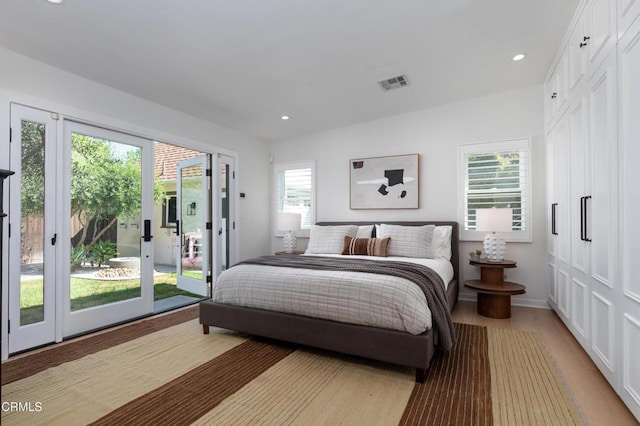 bedroom with light wood-style floors, access to outside, recessed lighting, and visible vents