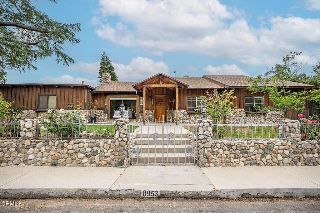 8953 Hillrose St, Sunland, CA 91040 - view of front facade with board and batten siding, a fenced front yard, and roof with shingles