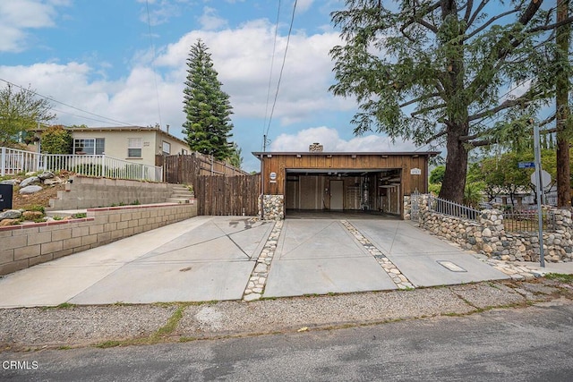 garage featuring fence and concrete driveway