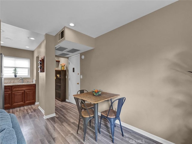 dining space with recessed lighting, baseboards, visible vents, and wood finished floors