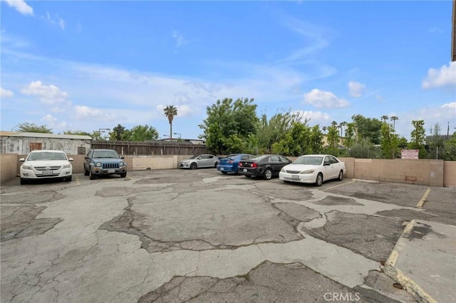 uncovered parking lot featuring fence