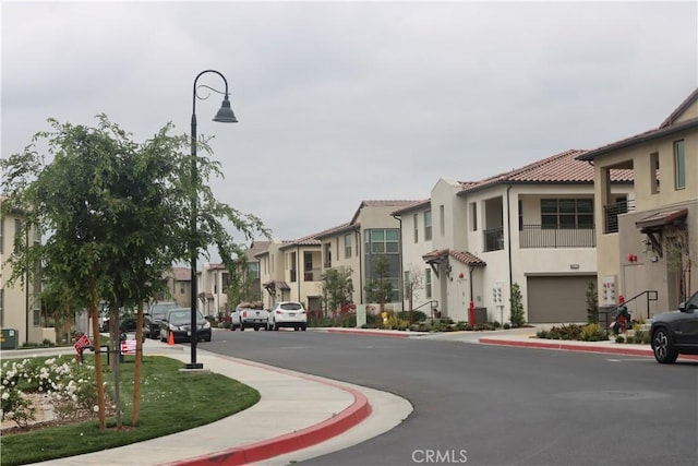 4211 E Malagon Privado Unit 66, Ontario, CA 91761 - view of street with a residential view, sidewalks, street lighting, and curbs