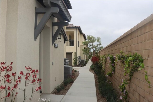 4211 E Malagon Privado Unit 66, Ontario, CA 91761 - view of side of home with central air condition unit, fence, and stucco siding
