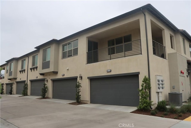 4211 E Malagon Privado Unit 66, Ontario, CA 91761 - view of property with central air condition unit, an attached garage, and stucco siding