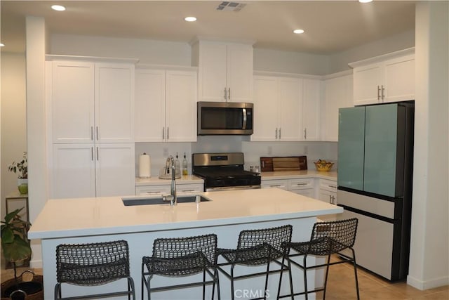 4211 E Malagon Privado Unit 66, Ontario, CA 91761 - kitchen featuring a sink, stainless steel appliances, white cabinetry, and visible vents
