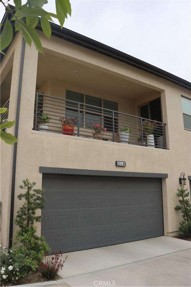 4211 E Malagon Privado Unit 66, Ontario, CA 91761 - modern home featuring a garage, stucco siding, concrete driveway, and a balcony