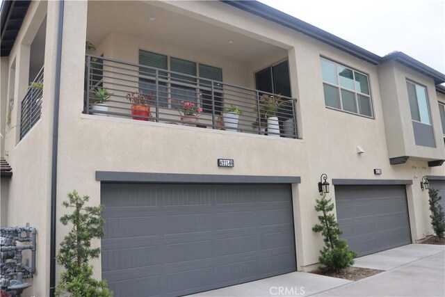 4211 E Malagon Privado Unit 66, Ontario, CA 91761 - view of front of house featuring a garage, stucco siding, and concrete driveway