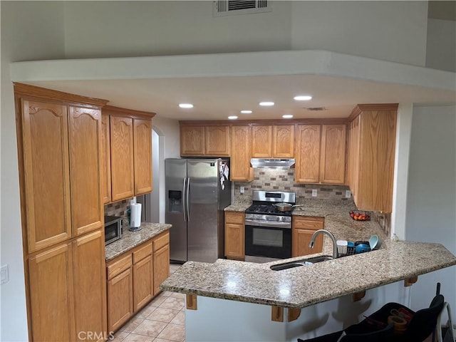 7548 Chase Ave, Hesperia, CA 92345 - kitchen with stainless steel appliances, a sink, under cabinet range hood, a peninsula, and a breakfast bar area