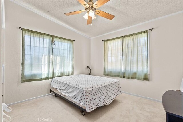 carpeted bedroom featuring crown molding, ceiling fan, a textured ceiling, baseboards, and vaulted ceiling